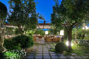 un patio con sofás y árboles en un jardín en La Medusa Hotel - Dimora di Charme en Castellammare di Stabia