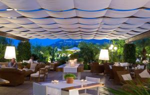 a restaurant with tables and chairs under a roof at La Medusa Hotel - Dimora di Charme in Castellammare di Stabia