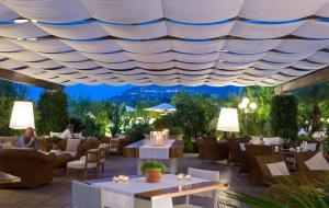 un restaurant avec des tables et des chaises sous un toit dans l'établissement La Medusa Hotel - Dimora di Charme, à Castellammare di Stabia