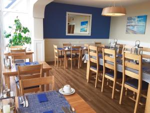 een eetkamer met tafels en stoelen en een blauwe muur bij Channel View Boutique Hotel - Adults Only in Paignton