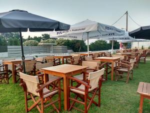 una fila di tavoli e sedie con ombrelloni di OCEAN-PACIFIC a Katakolo