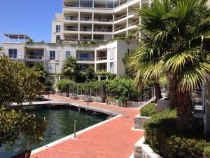 a large apartment building with a swimming pool and palm trees at 005 Marina Apartment in Cape Town
