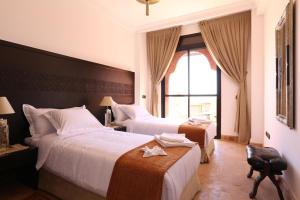 een hotelkamer met twee bedden en een raam bij Villa Nelya in Marrakesh +27 foto's