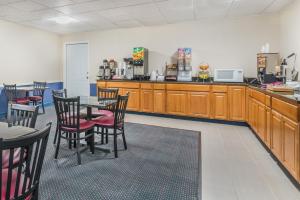 a restaurant with wooden cabinets and tables and chairs at Howard Johnson by Wyndham Bangor in Bangor