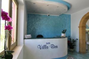 a reception desk in a room with a blue wall at B&B Villa Bea in San Vito lo Capo