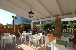a patio with white tables and chairs and a view at B&B Villa Bea in San Vito lo Capo