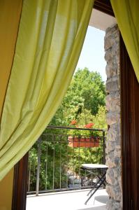 una ventana con cortinas verdes y una mesa en el balcón en Agriturismo Monte Cesima en Sesto Campano