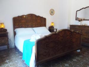 1 dormitorio con 1 cama con cabecero de madera en Relax Sui Monti Dauni, en Castelluccio Valmaggiore