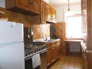 a kitchen with wooden cabinets and a white refrigerator at Relax Sui Monti Dauni in Castelluccio Valmaggiore