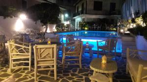 un patio con tavoli e sedie accanto alla piscina di Pirofani a Città di Lefkada