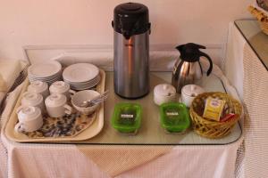 a glass table with a tray of dishes and a coffee maker at Casa Don Jose B & B in Puno