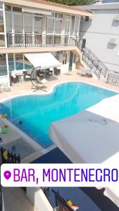 a swimming pool in front of a building with the words bar montgomery at Apartments Nensy in Bar