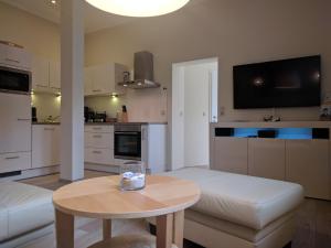 uma pequena sala de estar com uma mesa e uma cozinha em Zur Alten Post Prora em Binz