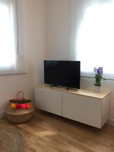 a living room with a flat screen tv on a white cabinet at Duplex Casco Histórico in Pontevedra