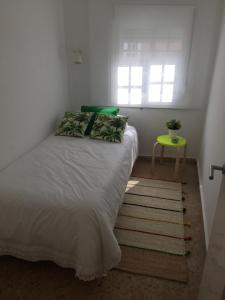 a bed in a room with a window and a table at Duplex Casco Histórico in Pontevedra