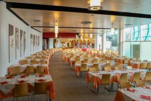 une grande salle de banquet avec des tables et des chaises. dans l'établissement Attico Villaggio Olimpico Sestriere, à Sestrières