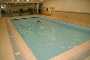 una persona che nuota in una grande piscina di Attico Villaggio Olimpico Sestriere a Sestriere