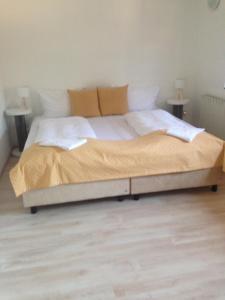 a large bed in a bedroom with two tables at Hotel Gloria Budapest City Center in Budapest