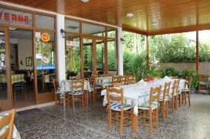 a restaurant with a table with white tables and chairs at Hotel Hermes in Olympia