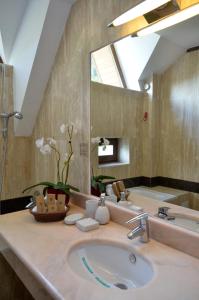 bagno con lavandino e grande specchio di Hotel Cumpatu a Sinaia