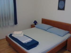 a bedroom with a bed with blue pillows at Apartmani Maver in Sveti Filip i Jakov