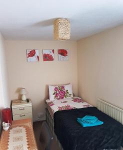 a small bedroom with a bed and a night stand at Amber Guesthouse in Derby