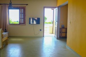 an empty room with a door and a television on the wall at Pirgos Naxos in Aliko Beach