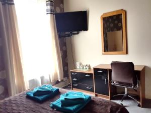 a bedroom with a bed with a desk and a mirror at Amber Guesthouse in Derby