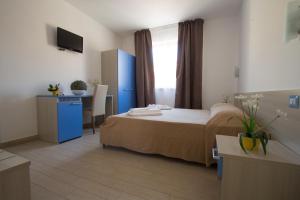 a hotel room with a bed and a desk and a television at B&B Baglio Santa Croce in Porto Empedocle