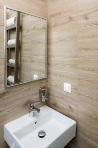 La salle de bains est pourvue d'un lavabo blanc et d'un miroir. dans l'établissement Lola's Hotel, à Platanias