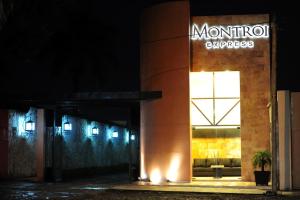 a building with a sign on the side of it at night at Hotel Montroi Express in Colima