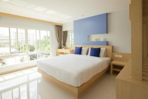 a bedroom with a large bed and a large window at Charisma Residence in Rayong