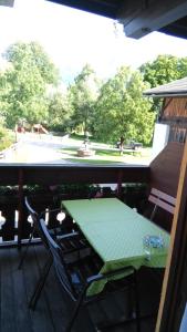 a table and chairs on a porch with a view of a park at Privatzimmer Bundschuh in Amlach