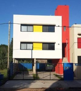 un edificio blanco con ventanas amarillas y negras en Departamentos Esperanza en Colón