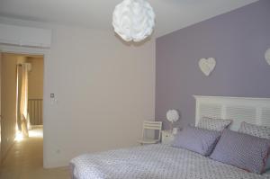 a bedroom with a bed with blue pillows and a chandelier at Il était une fois... in Malaucène +7 photos