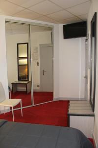 a room with a red carpet and a mirror at Hôtel de la Meuse in Charleville-Mézières