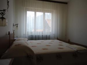 Lozzo CadoreにあるCasa Giudittaのベッドルーム1室(大型ベッド1台、窓付)