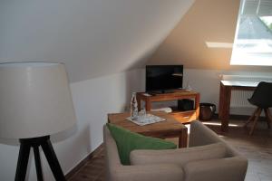 ein Wohnzimmer mit einem Sofa, einem Tisch und einem TV in der Unterkunft Gästezimmer Gier in Dahlem