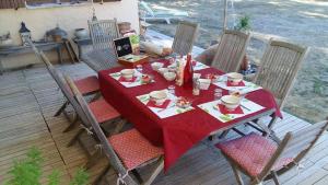 a table with a red table cloth on a deck at Clos de l'Artuby in Valderoure