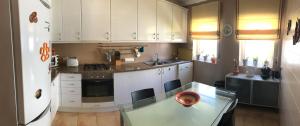 a kitchen with a glass table and a white refrigerator at Varandas da Sandia in Vila Praia de Âncora