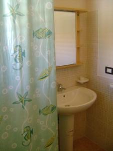 uma casa de banho com uma cortina de chuveiro e um lavatório em Villa Flavia em Noto Marina