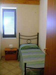 um quarto com uma cama, uma janela e uma mesa em Villa Flavia em Noto Marina