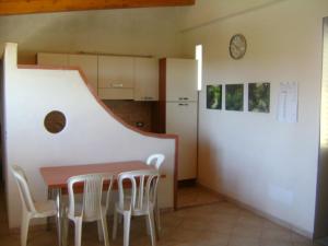 uma cozinha com mesa e cadeiras e um relógio em Villa Flavia em Noto Marina