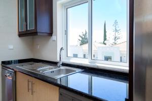 a kitchen with a sink and a window at For Sea Apartment in Cabanas de Tavira
