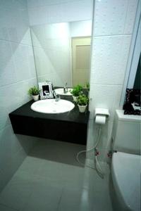 a bathroom with a sink and a mirror and a toilet at Baan Vor. Sumongkol Service Apartment in Khon Kaen