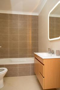 a bathroom with a tub and a toilet and a sink at For Sea Apartment in Cabanas de Tavira
