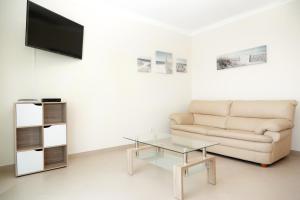 un soggiorno con divano e tavolino in vetro di For Sea Apartment a Cabanas de Tavira