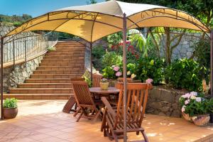 a patio with a table and chairs under an umbrella at La Casa Del Campo in Vega de San Mateo
