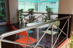 a balcony with tables and chairs in a building at Baan Vor. Sumongkol Service Apartment in Khon Kaen