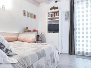 サン・ジョヴァンニ・ルパトートにあるCasetta Bianca B&Bの白いベッドルーム(ベッド1台、テレビ付)